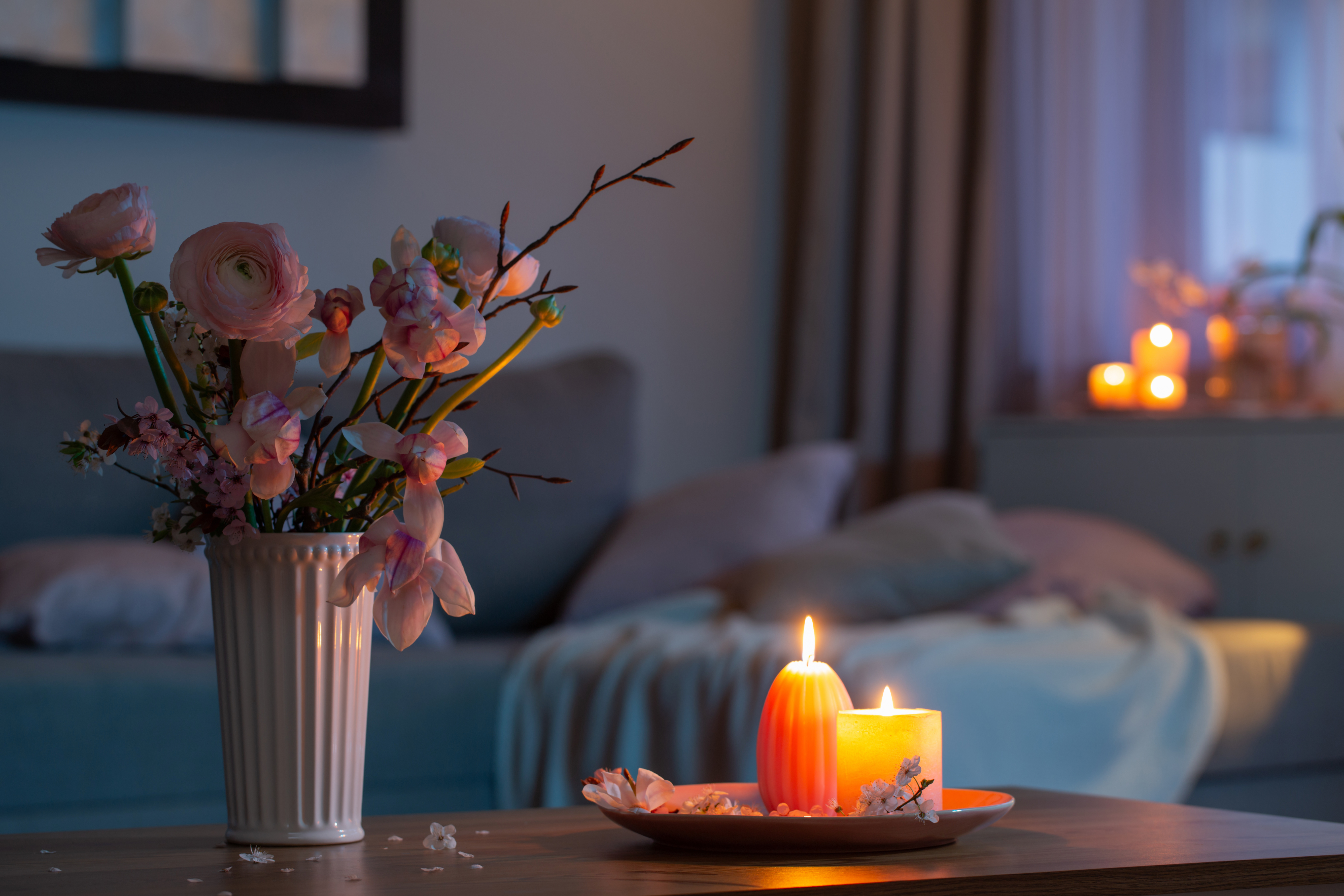 A quiet home corner in soft light with flowers and a few lit candles, a gentle place to remember a baby